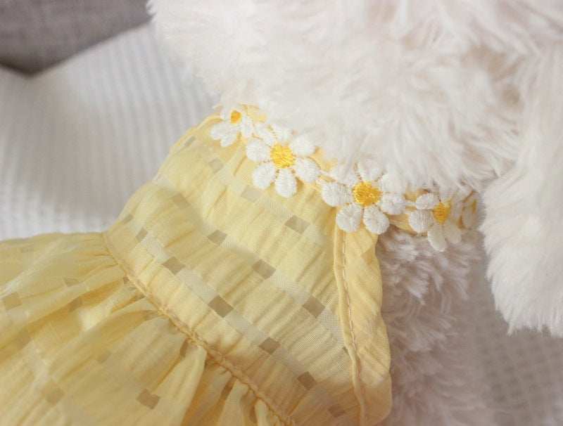 Close-up of a yellow fabric with floral embellishments on a fluffy white background