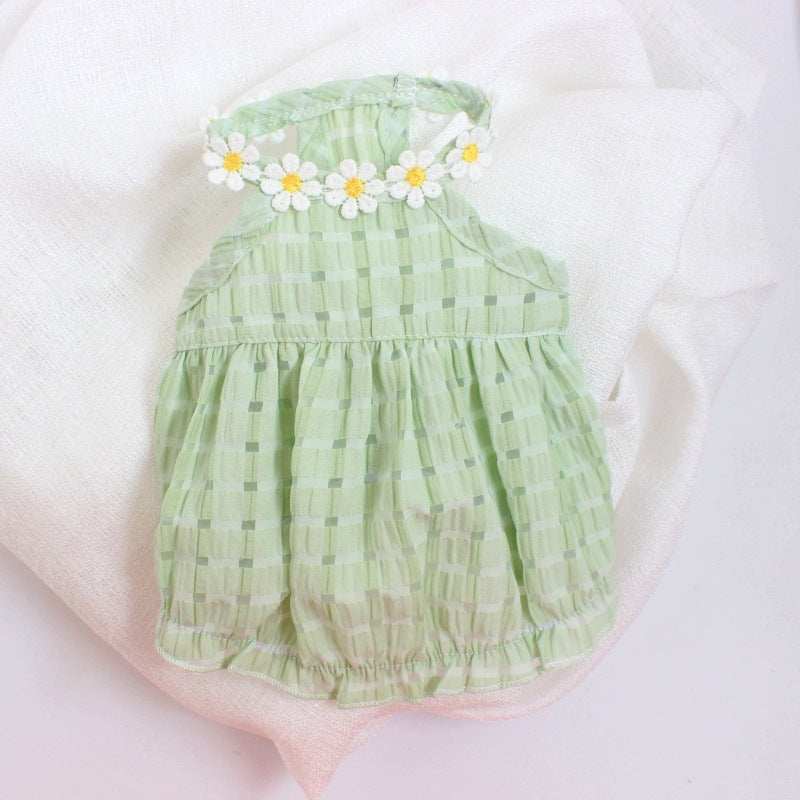 Green baby romper with floral headband on a white background