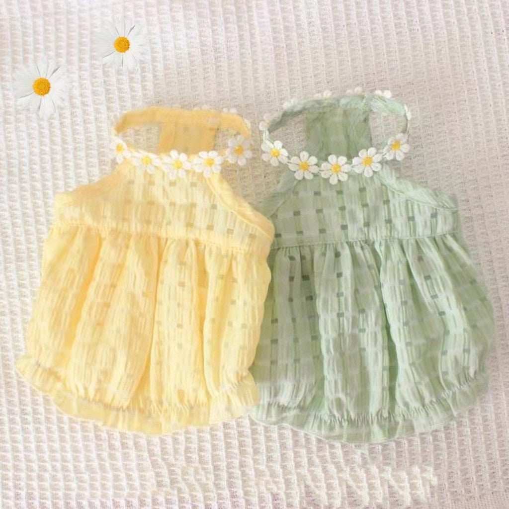 Two baby rompers, one yellow and one green, with floral headbands on a textured white background.