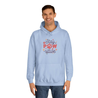 Stay Pawsitive Unisex Hoodie light blue pullover on male model with paw print graphic and kangaroo pocket