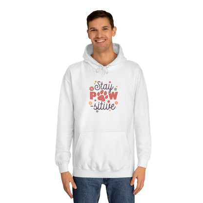 Stay Pawsitive Unisex Hoodie white pullover on smiling male model with paw graphic and floral accents and kangaroo pocket