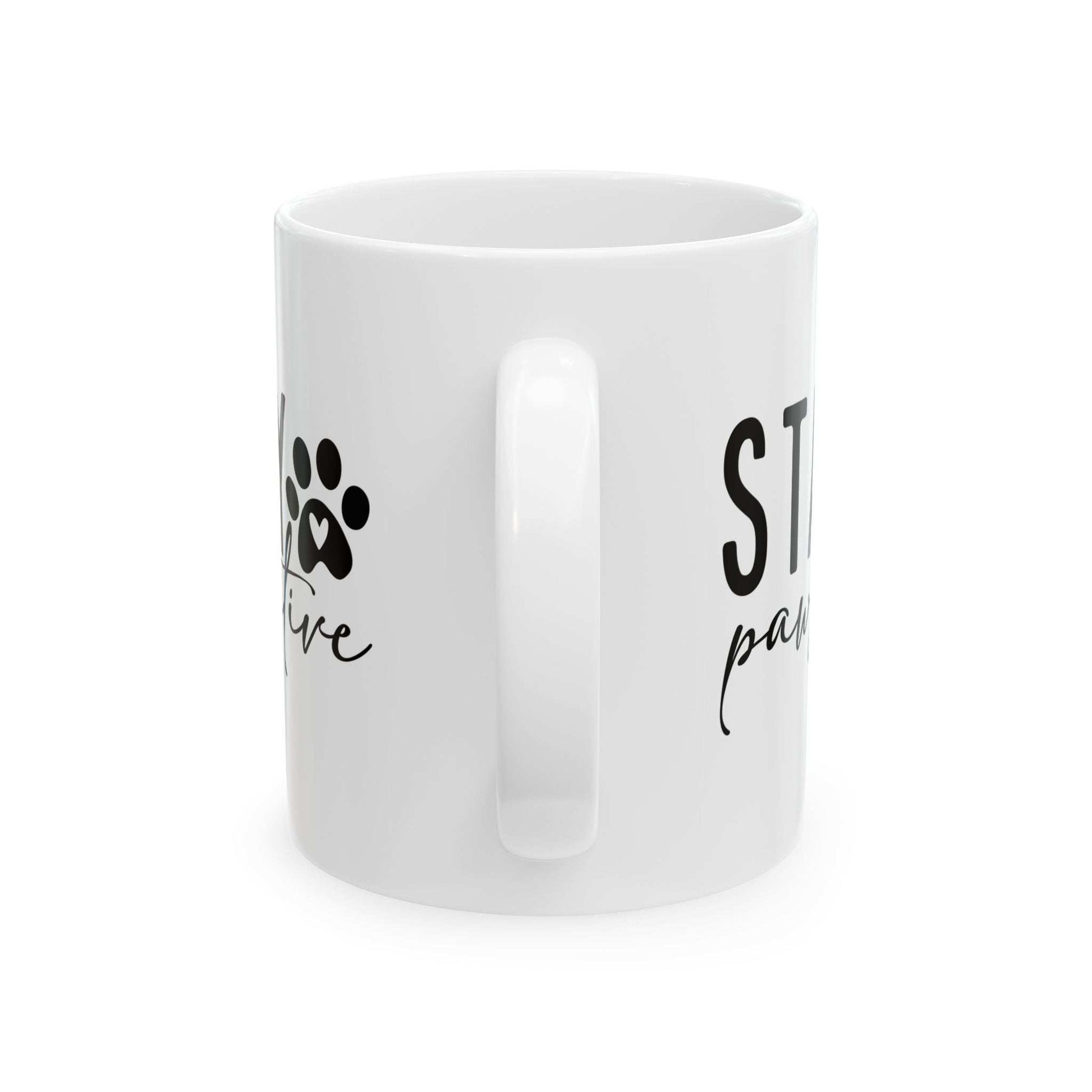 White ceramic Stay Pawsitive Mug with black paw print design and positive message from Printify
