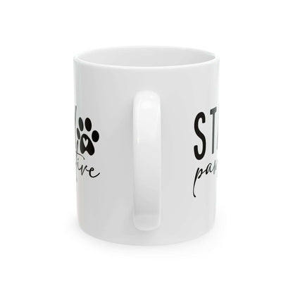 White ceramic Stay Pawsitive Mug with black paw print design and positive message from Printify